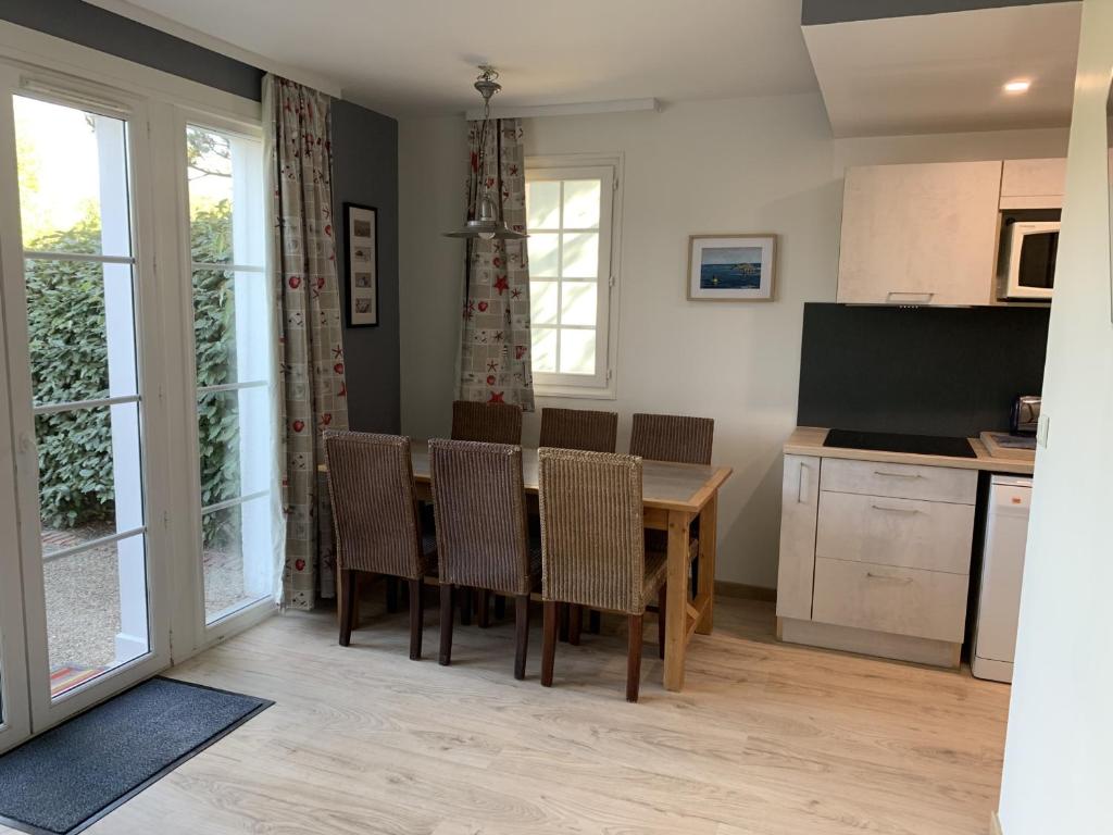a kitchen and dining room with a table and chairs at Maison Familiale avec Terrasse, 2 Chambres, Accès Plage et Golf - Animaux Bienvenus - FR-1-482-57 in Fort-Mahon-Plage