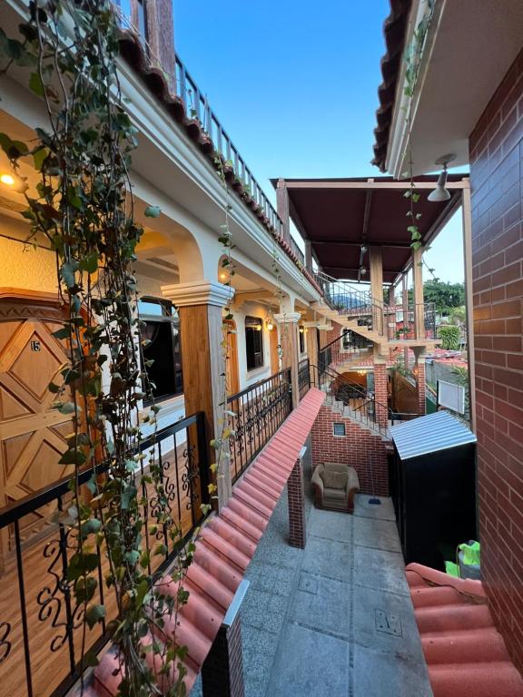 a balcony of a building with red stairs and vines at Posada don Miguel in Panajachel