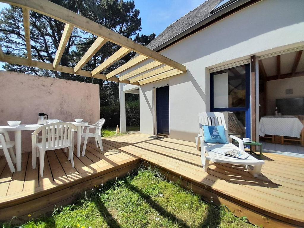 una terraza de madera con mesa y sillas. en Villa Carnac, 3 pièces, 6 personnes - FR-1-477-207 en Carnac