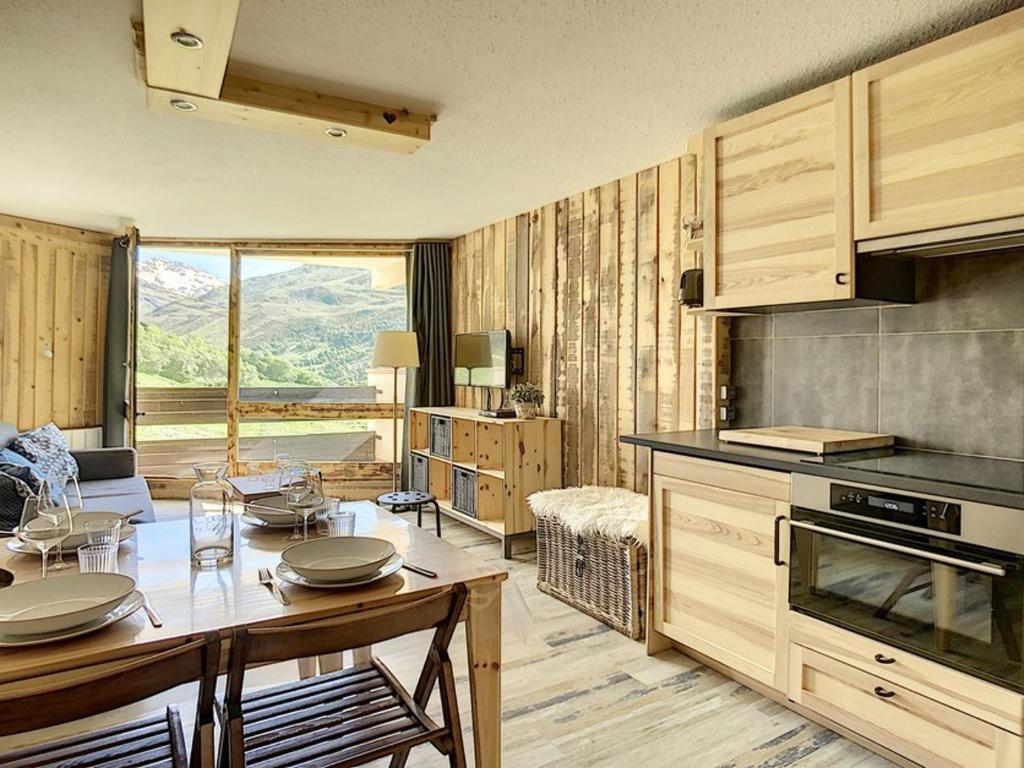 une cuisine avec une table et une salle à manger dans l'établissement Bel Appart Rénové · 6 Pers · Pied des Pistes · Balcon · 2 Flocons Bronze - FR-1-344-776, aux Menuires