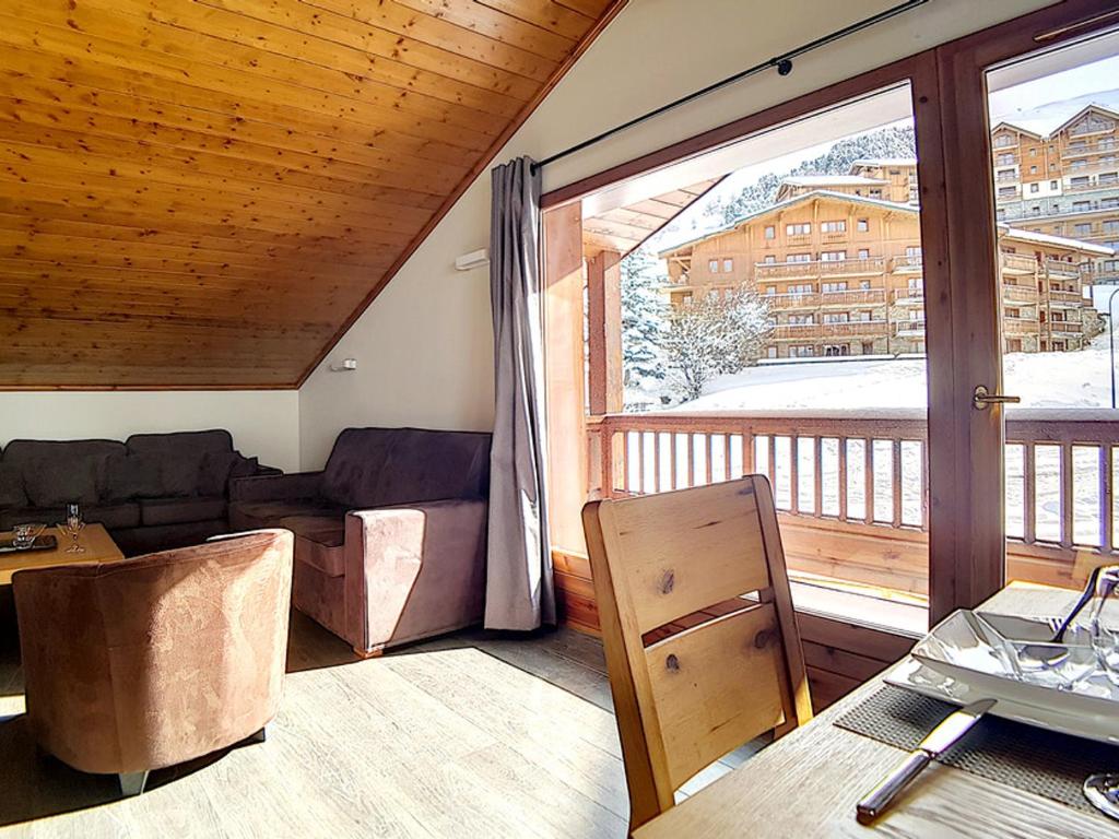 a living room with a couch and a large window at Appartement spacieux et rénové, 10 personnes, 4 Flocons OR, sauna et hammam - FR-1-344-786 in Levassaix