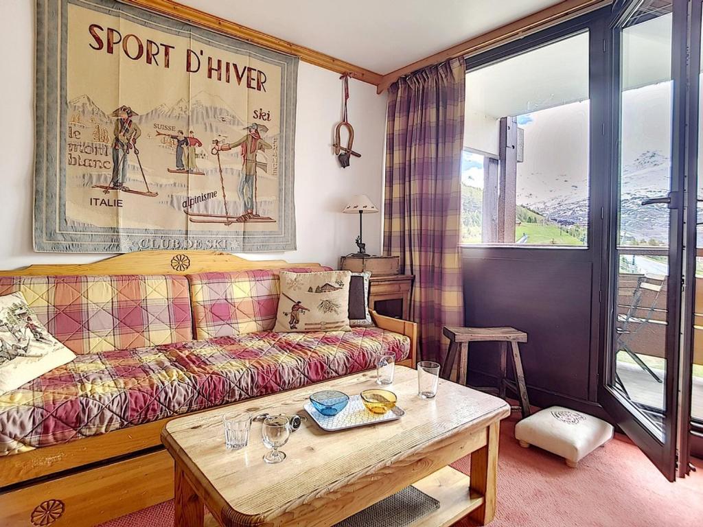 un salon avec un canapé et une table dans l'établissement Charmant T2 avec Balcon Sud, Proche Pistes et Commerces, Idéal Familles, Les Belleville - FR-1-344-838, aux Menuires