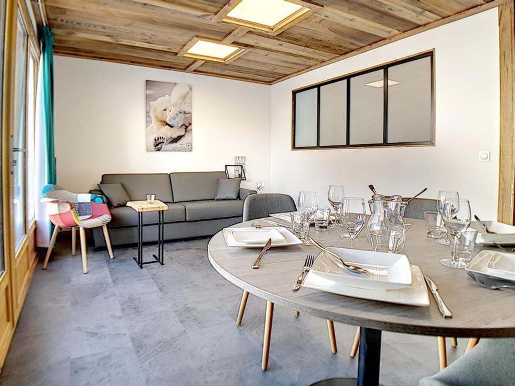 a living room with a table and a couch at Appartement Les Menuires, 2 pièces, 6 personnes - FR-1-344-831 in Levassaix