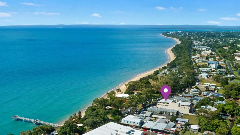 uma vista aérea de uma praia com um marcador rosa em Eden by the Bay em Hervey Bay