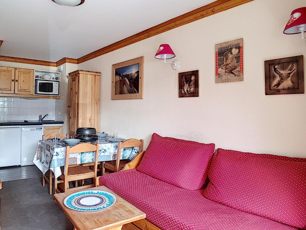 uma sala de estar com um sofá vermelho e uma mesa em Appartement Les Menuires, 2 pièces, 4 personnes - FR-1-344-980 em Les Bruyères