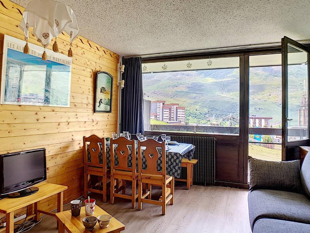 un salon avec un canapé, une télévision et une table dans l'établissement Appartement Lumineux 6 Pers. · Balcon Sud · Accès Direct aux Pistes · Garage en Option · La Croisette - FR-1-344-1017, aux Menuires