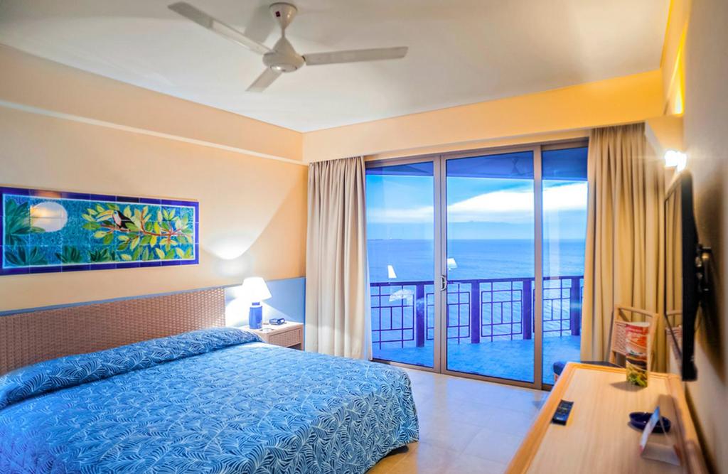 um quarto com uma cama e vista para o oceano em ZUANA BEACH RESORT SUITE PARA 6 PERSONAS 2 HABT 2BAÑOS em Santa Marta