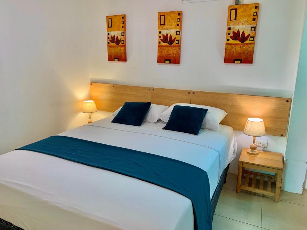 a bedroom with a bed with blue and white sheets at Hostal Casa Latina in Manta