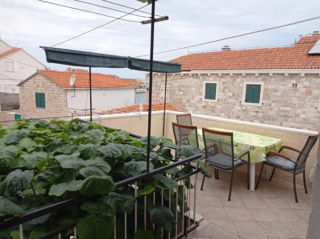 eine Terrasse mit einem Tisch und Stühlen auf dem Balkon in der Unterkunft Apartment Perica - 10 m from sea in Postira