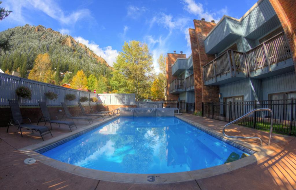 a large swimming pool in a yard with a house at Shadow Mountain Lodge in Aspen