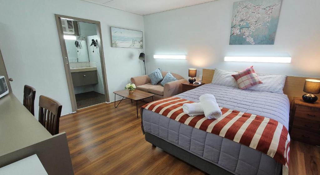 1 dormitorio con 1 cama y sala de estar en Morwell Parkside Motel, en Morwell