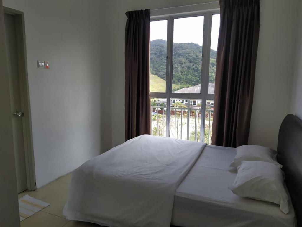 a bed in a room with a large window at Golden Hills Pasar Malam 3 Bedroom Apartment J LouvRe in Tanah Rata