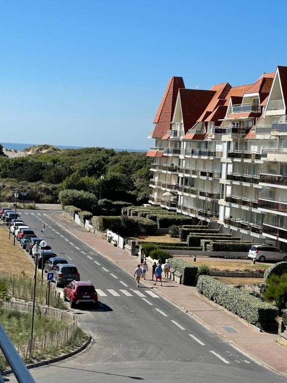 une route avec des voitures garées sur le côté d'un bâtiment dans l'établissement Le Touquet - Superbe appartement 3 chambres - Proche mer & centre - Wifi, à Le Touquet-Paris-Plage