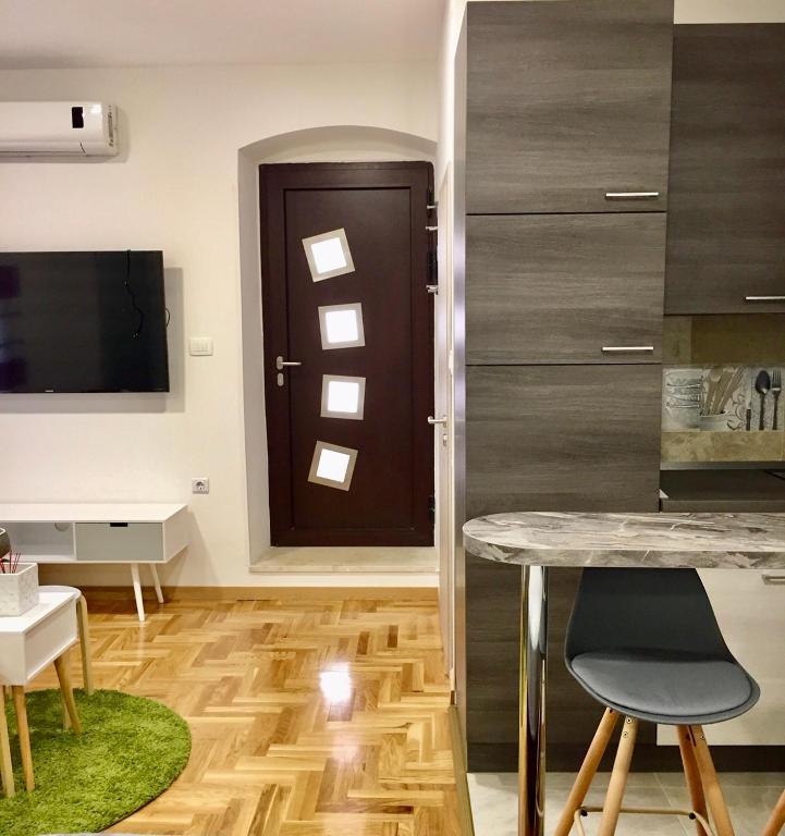 a kitchen with a table and a door with lights at Sweet studio apartment Living in Rijeka in Rijeka