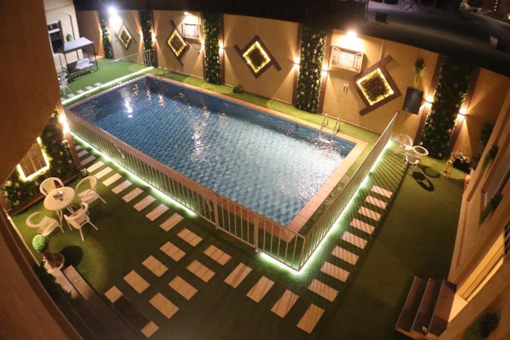 een uitzicht op een zwembad in de nacht bij Swat Olaya Hotel Apartments in Al Khobar
