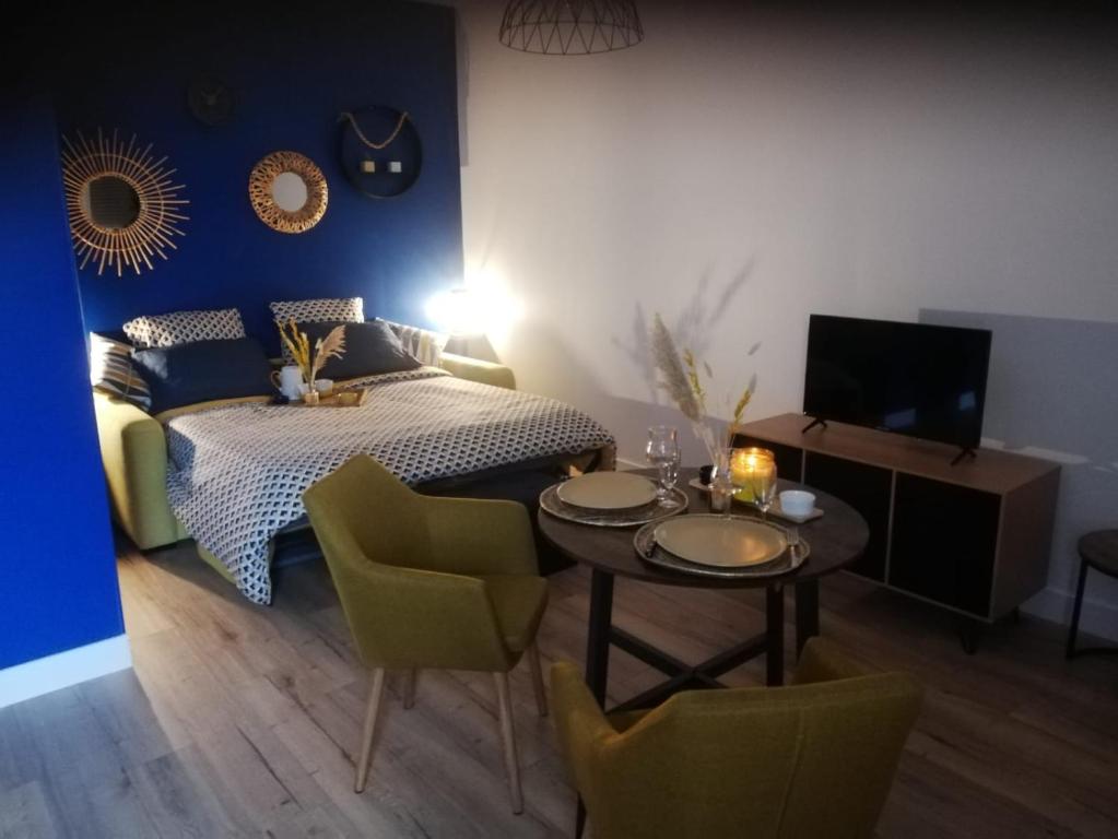 sypialnia z łóżkiem, stołem i krzesłami w obiekcie Gite rural cocooning en Baie de Somme w mieście Vron