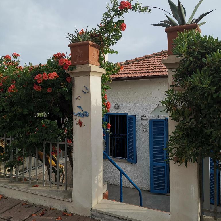 een huis met blauwe luiken en bloemen erop bij la baracca dei pescatori in Follonica