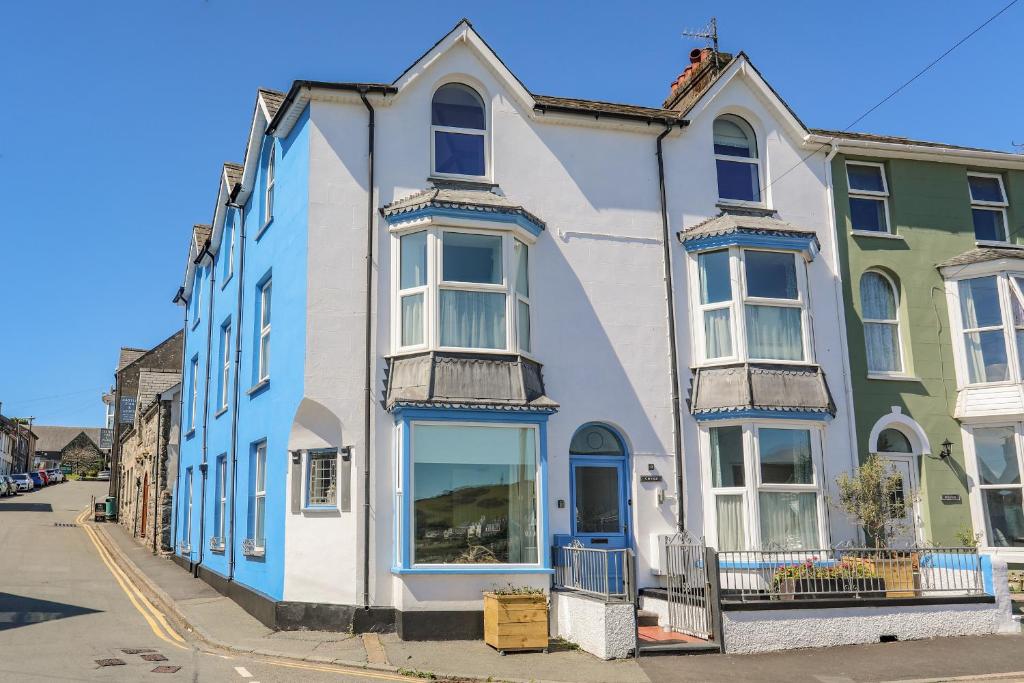 a blue and white house on a street at Gwynle - Criccieth in Criccieth