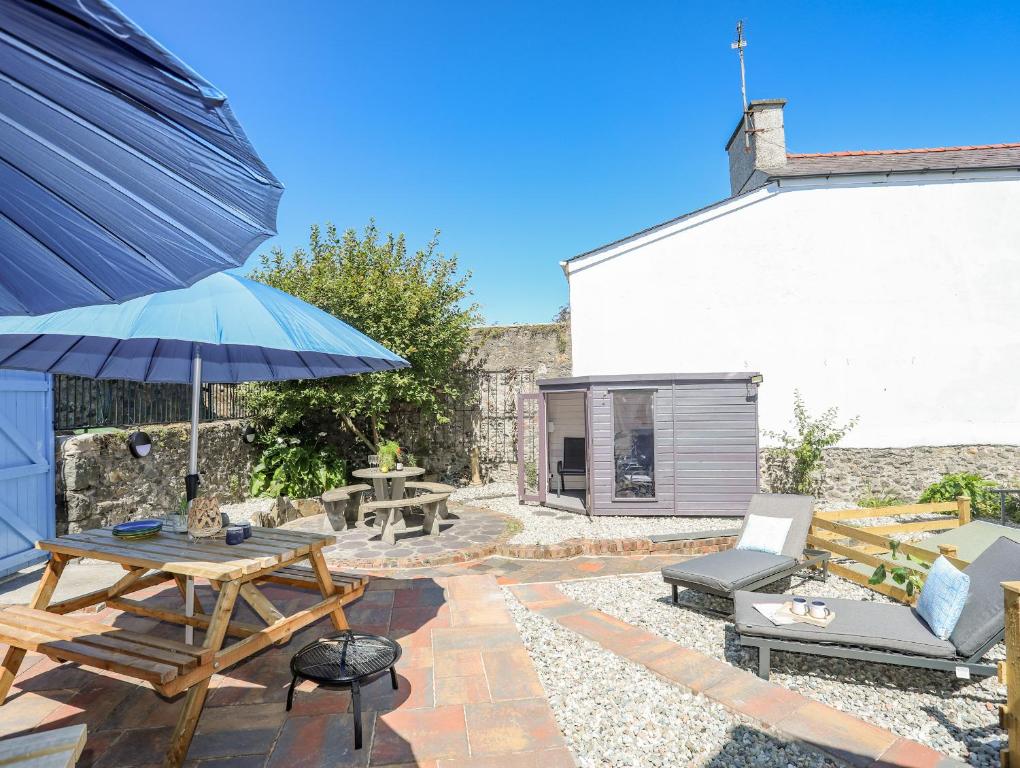 een patio met een picknicktafel en een parasol bij Gwynle - Criccieth in Criccieth
