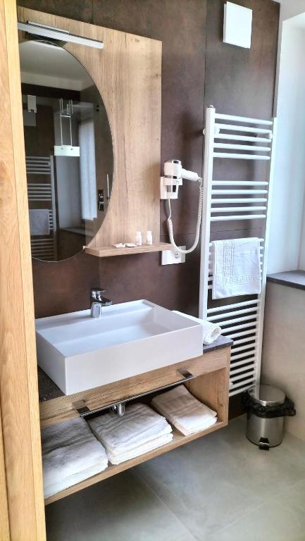 łazienka z białą umywalką i lustrem w obiekcie Agritur La Fenice w mieście Brez