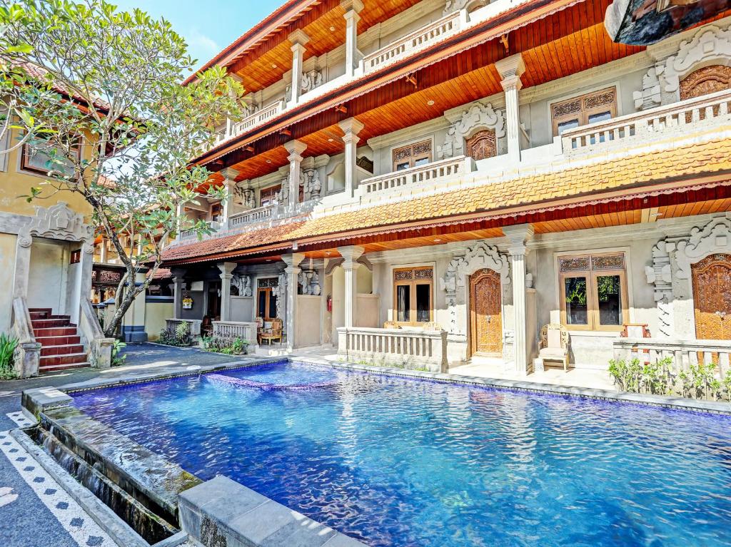a large house with a swimming pool in front of it at OYO Collection O 91125 Puri Dewa Bharata in Jimbaran