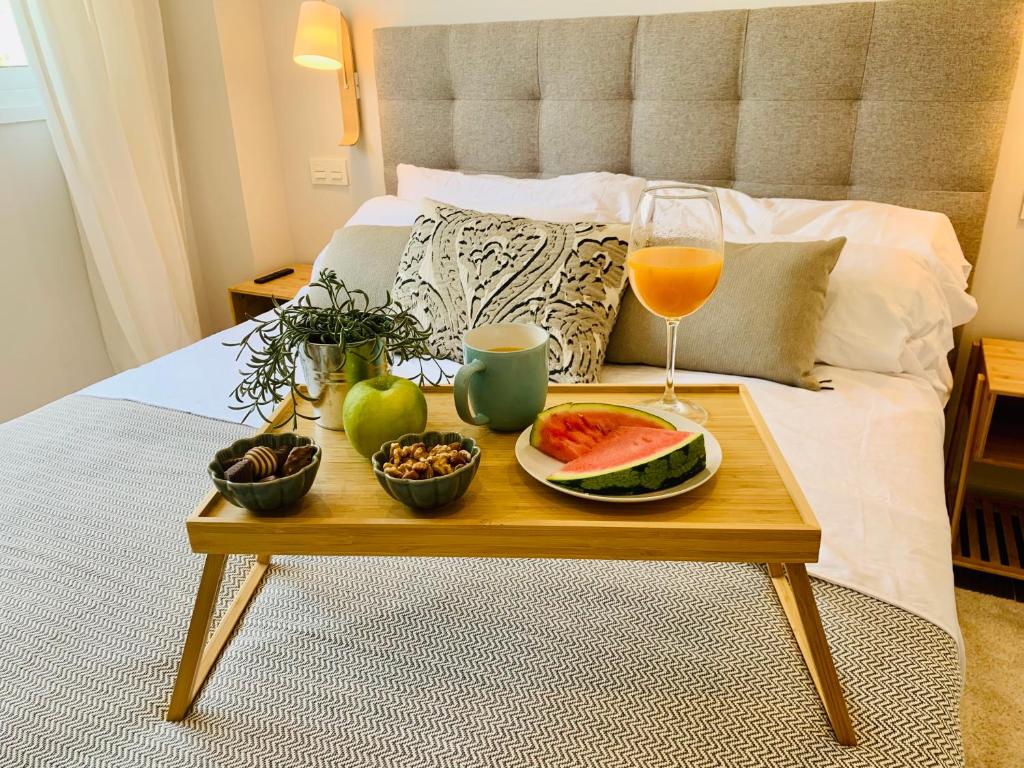 a tray of food and a glass of wine on a bed at Sea view luxury new apartment Marbella Port in Marbella