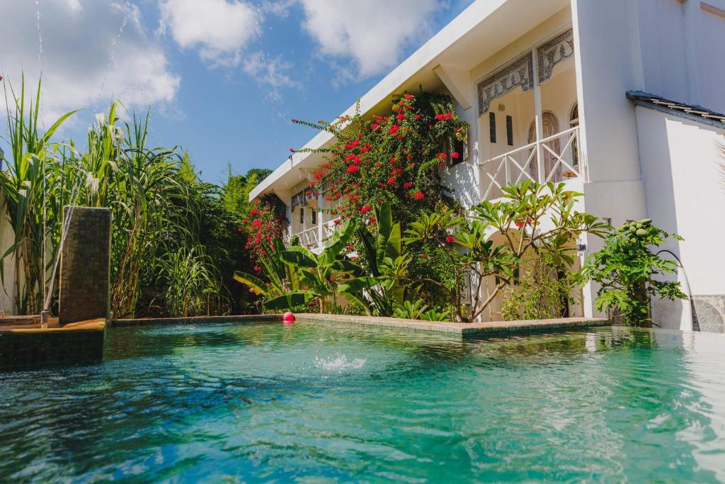 a swimming pool in front of a house at ISLA INDAH RETREAT boutique hotel in Nusa Lembongan