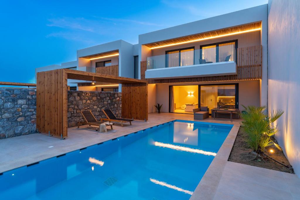 une maison avec une piscine en face de celle-ci dans l'établissement Aethrion Villas & Suites, à Gennadi