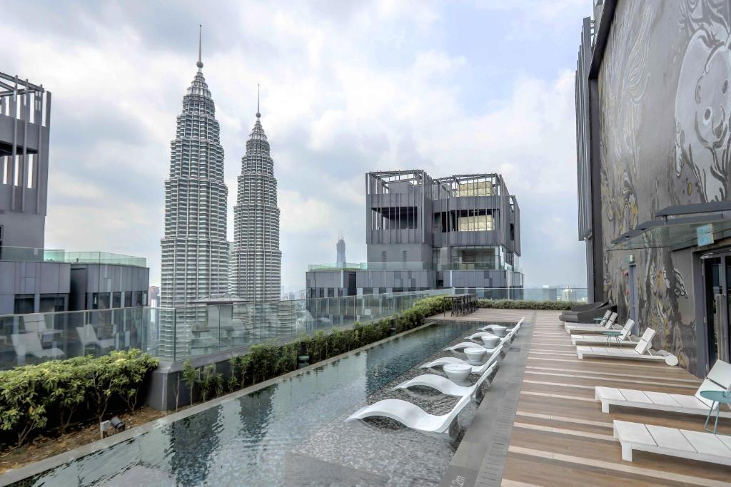 H&N Luxury Suites KLCC في كوالالمبور: اطلالة على ابراج بتروناس من مبنى مع مسبح