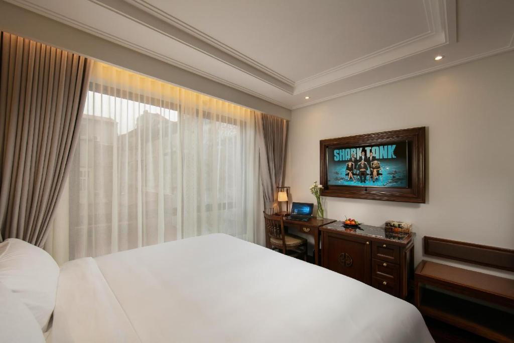 a hotel room with a bed and a television at Lucien Hanoi Lakeside Hotel & Rooftop in Hanoi