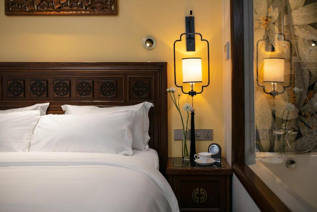 a hotel room with a bed and a bath tub at Lucien Hanoi Lakeside Hotel & Rooftop in Hanoi