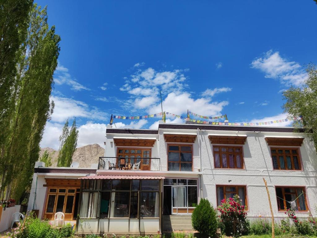 una casa blanca con un cielo azul en el fondo en Nilza Guest House, en Leh