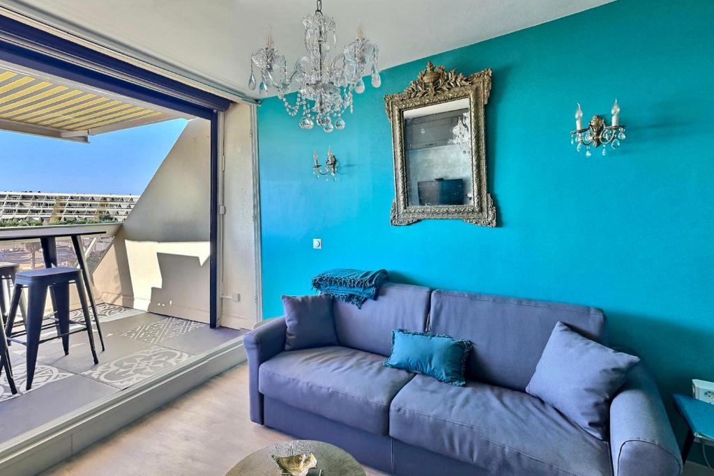 - un salon bleu avec un canapé violet et un miroir dans l'établissement appartement luxe balnéothérapie au village naturiste du cap d'agde, au Cap d'Agde