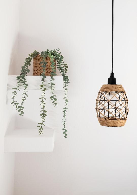 a hanging pendant light with a basket and a plant at Dorkas Luxury Rooms&Apartments in Livadakia