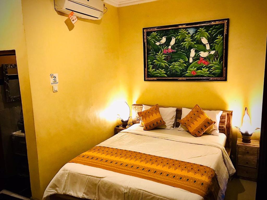 une chambre avec un lit avec un tableau sur le mur dans l'établissement Ubud home stay, à Gianyar