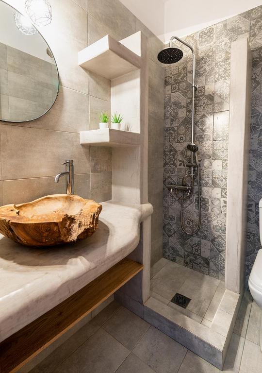 a bathroom with a wooden sink and a shower at Dorkas Luxury Rooms&Apartments in Livadakia