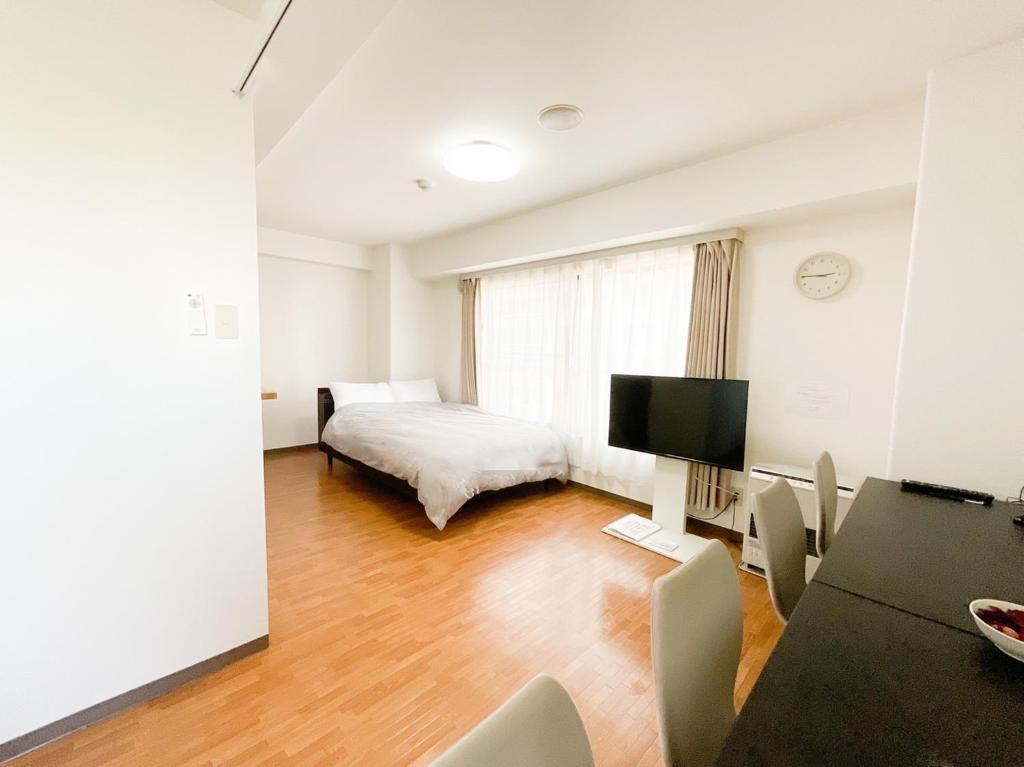 - une chambre avec un lit et un bureau avec une télévision dans l'établissement Park Hills East 23A / Vacation STAY 4384, à Sapporo