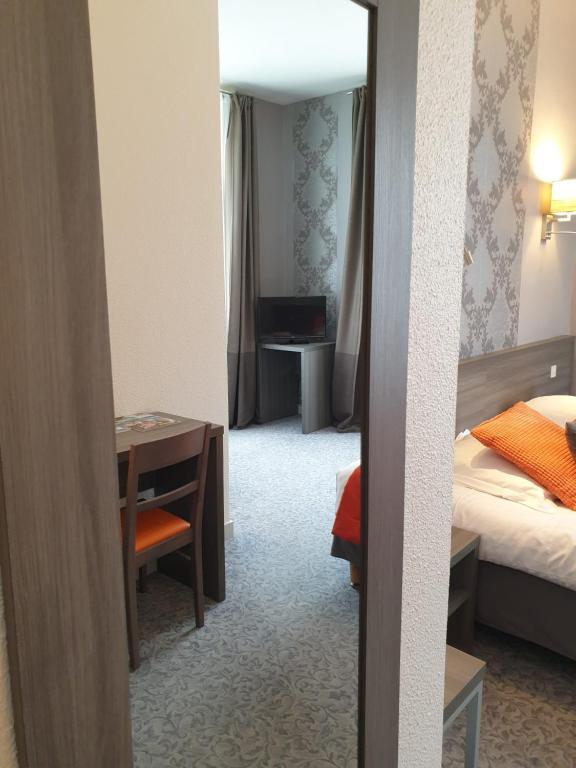Postel nebo postele na pokoji v ubytování Hôtel Le Rohan Charme et Caractère