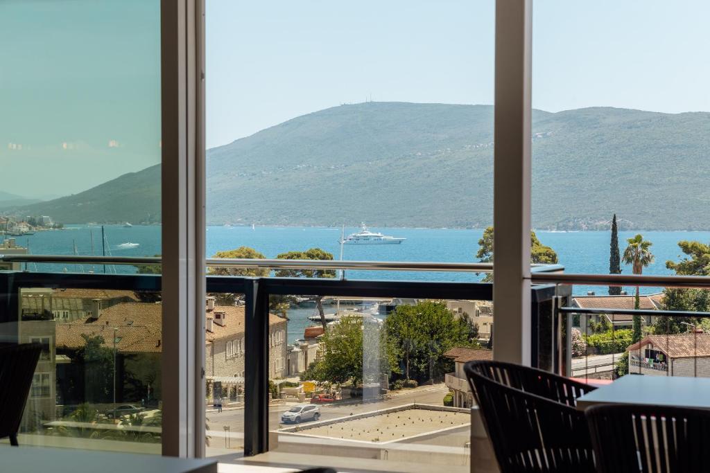 einen Blick auf das Wasser aus einem Zimmer mit Stühlen in der Unterkunft Centar Novi in Herceg-Novi