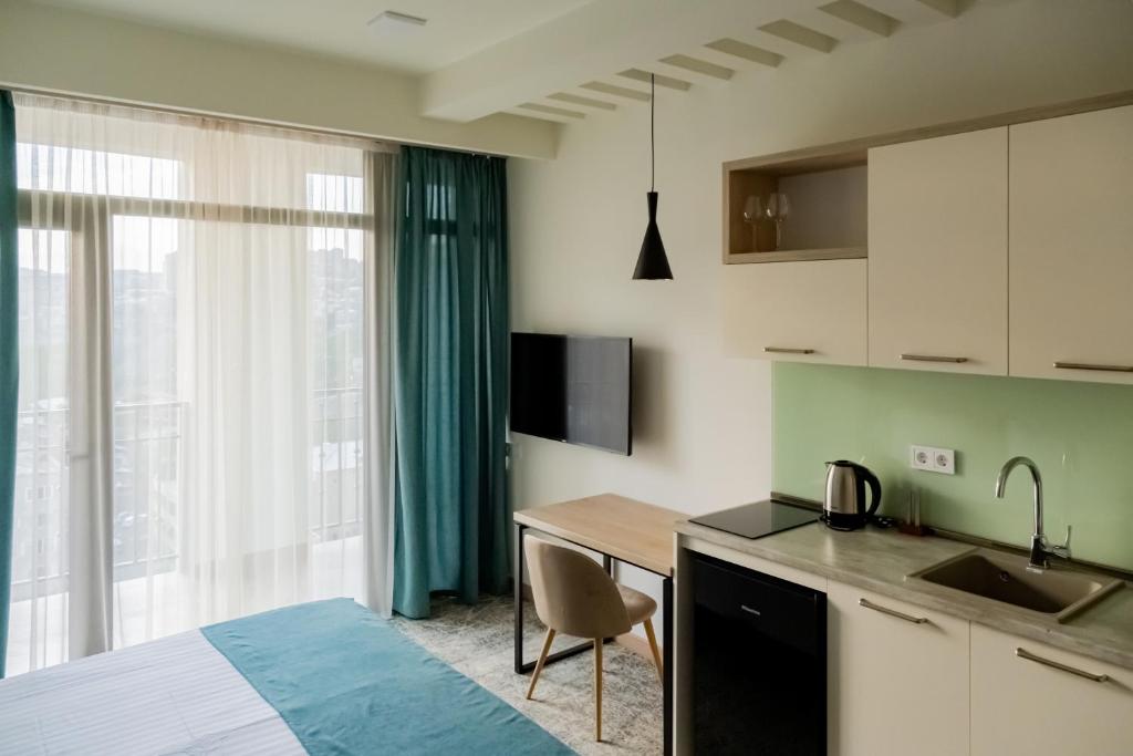 um quarto com uma cama, uma cozinha e uma mesa em Rooftop Apart-Hotel em Yerevan