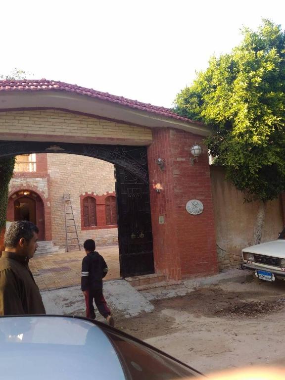 a young boy walking into a brick building at Villa Dr. Atef Darwish in Alexandria