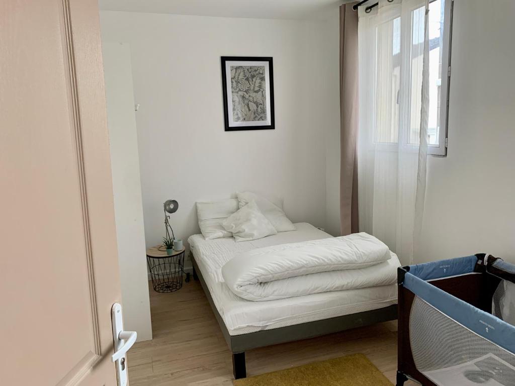 Kleines Zimmer mit einem Bett und einem Fenster in der Unterkunft Agréable maison avec parking gratuit sur place. in Saint-Denis