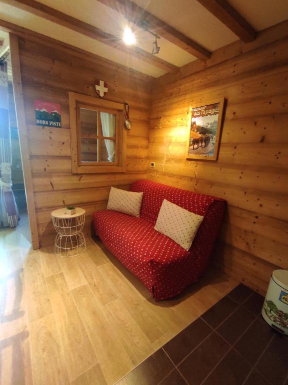 - un canapé rouge dans une chambre dotée de murs en bois dans l'établissement Pan 125B, à Manigod