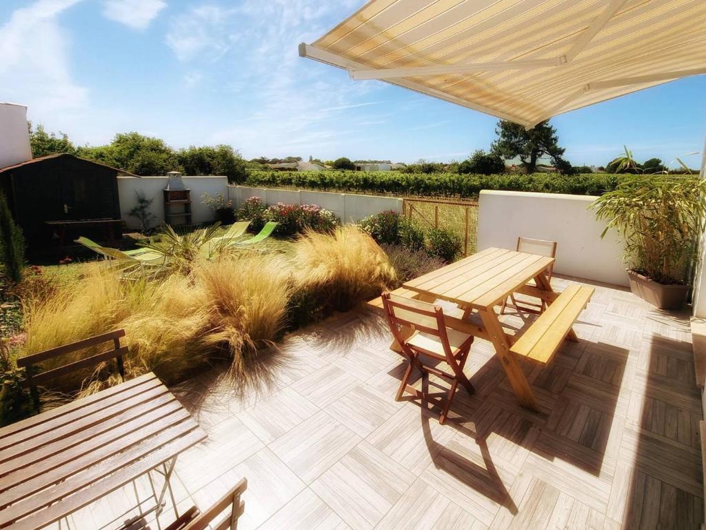 un patio avec deux bancs, une table et des chaises dans l'établissement Maison neuve, 6 couchages, proche plage avec jardin, terrasse et parking, animaux admis. - FR-1-246A-128, à Saint-Pierre-dʼOléron