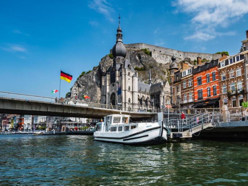 un barco está atracado junto a un puente y edificios en Pénichettes Dinant Evasion en Dinant