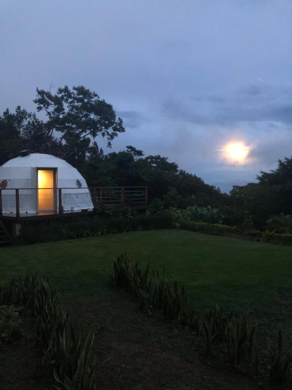 a white dome tent in a field at night at Casa Luna Glamping in Sorá