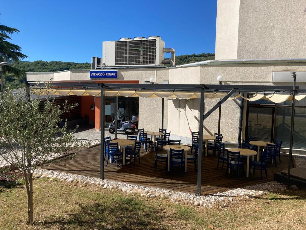 コペルにあるプレノチッシャ プリソヘのデッキにテーブルと椅子を用意したレストラン