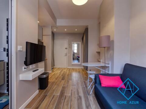 un salon avec un canapé bleu et une télévision dans l'établissement Port de Nice- Résidence Neptune- Superbe studio!, à Nice