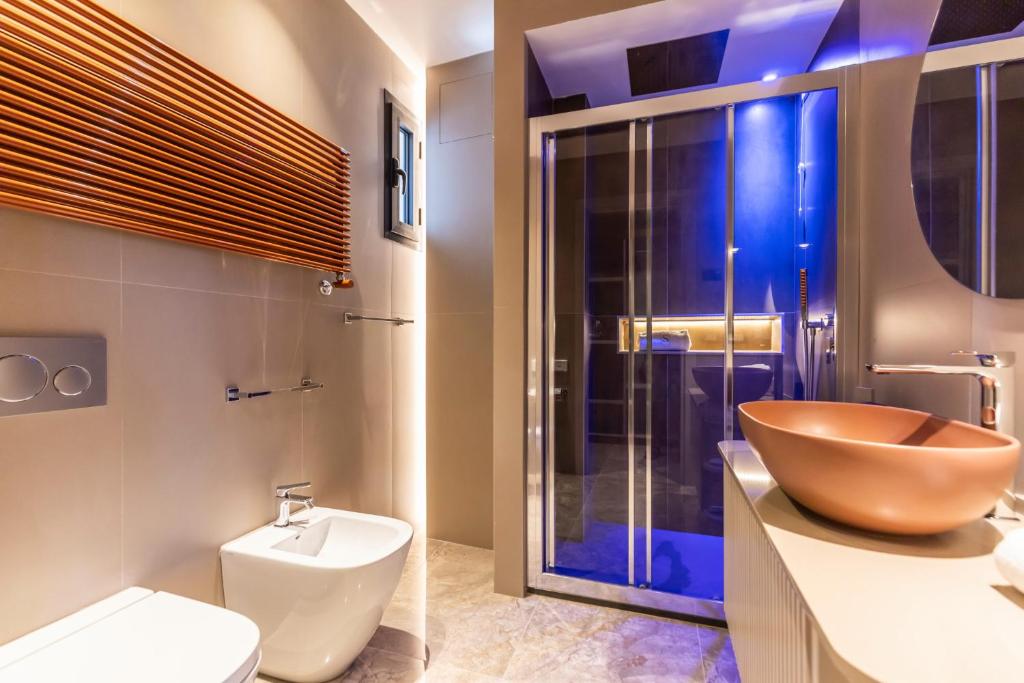 a bathroom with a wooden bowl sink and a toilet at Solmaris Tropea Rooms & Suites in Tropea