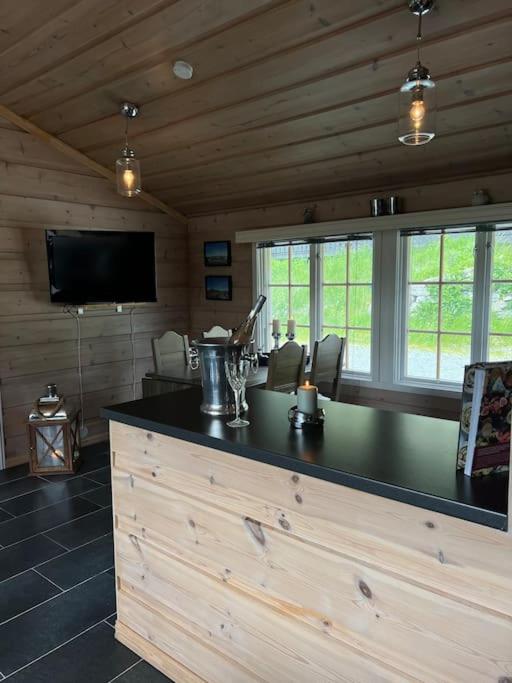 a kitchen with a bar with a television in a cabin at Beitostølen sentralro in Beitostøl